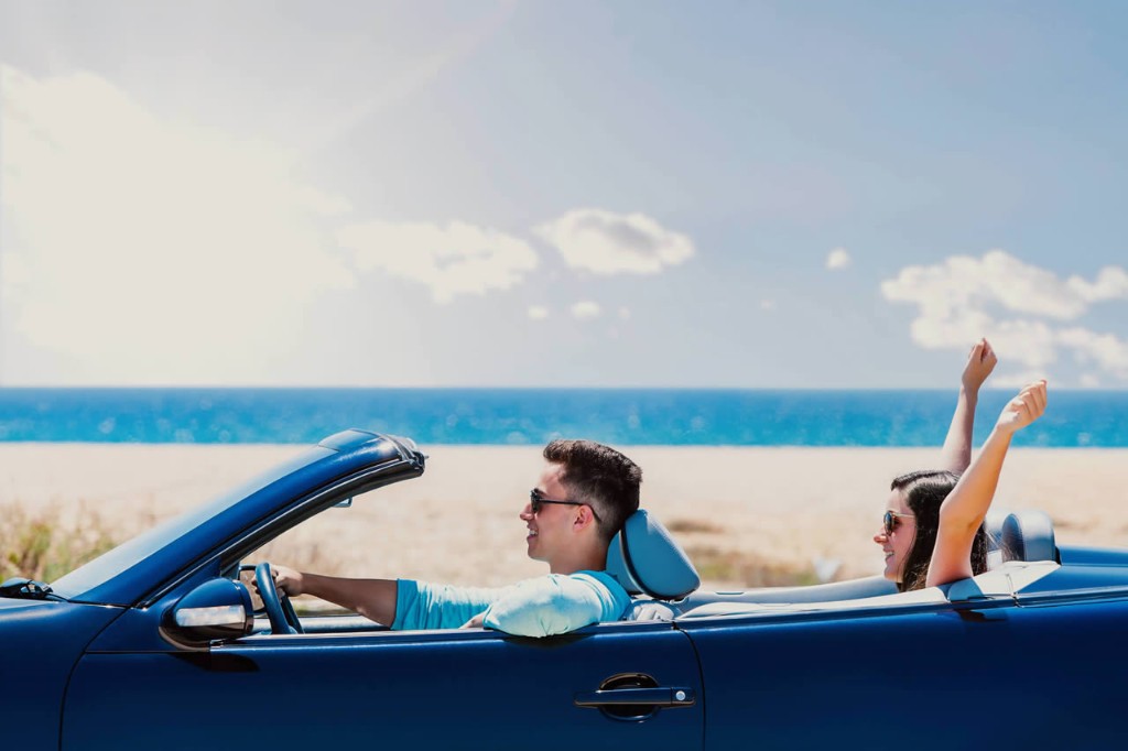 Couple enjoying a convertible drive along the coast